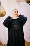 Cloche silk abaya with satin belts on sleeves and chest.