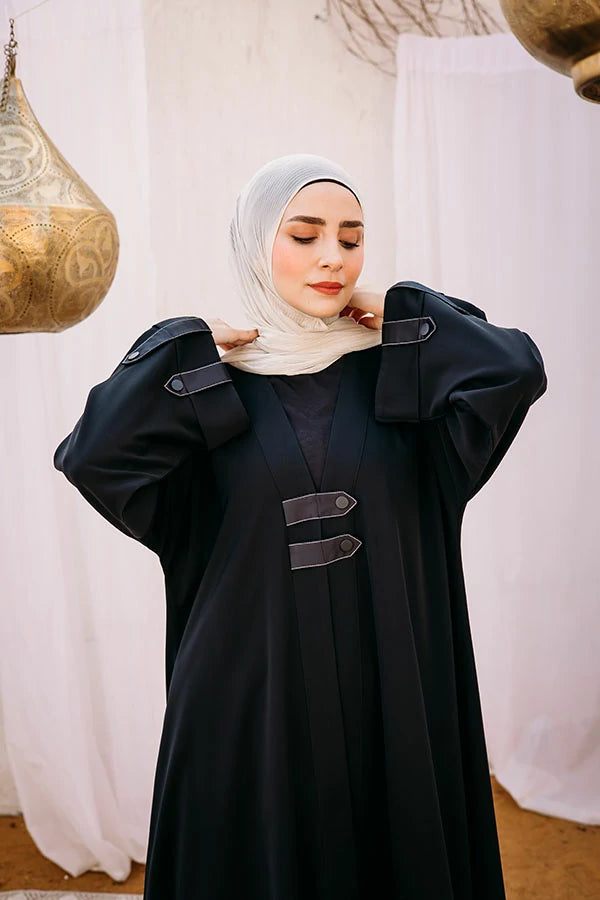 Cloche silk abaya with satin belts on sleeves and chest.