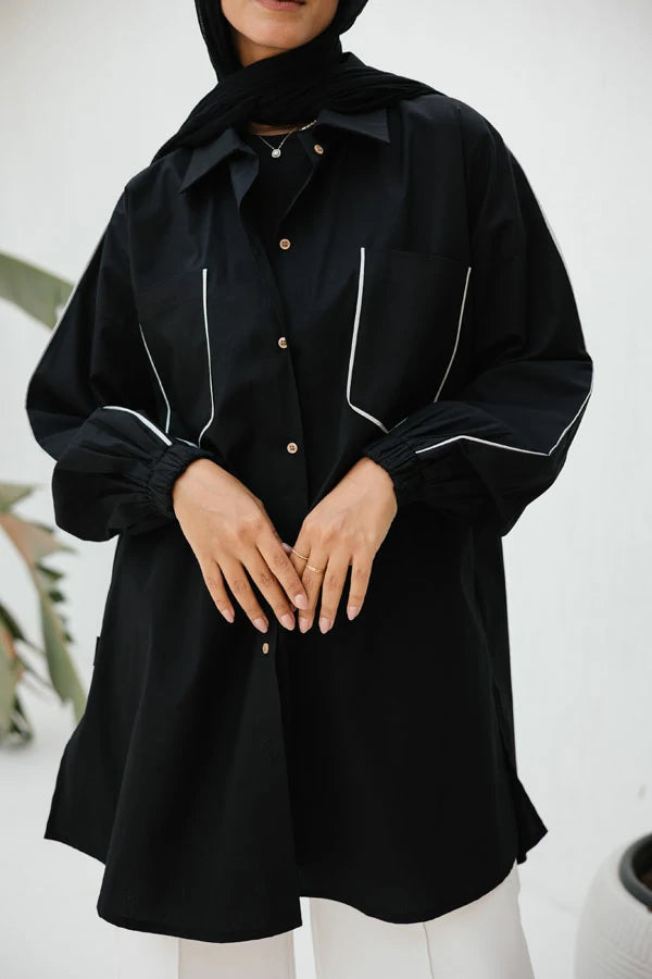 Black poplin shirt with light grey piping on pockets.