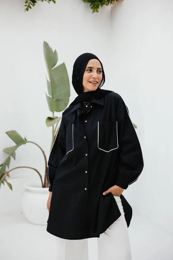 Black poplin shirt with light grey piping on pockets.