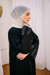 Cloche silk abaya with satin belts on sleeves and chest.